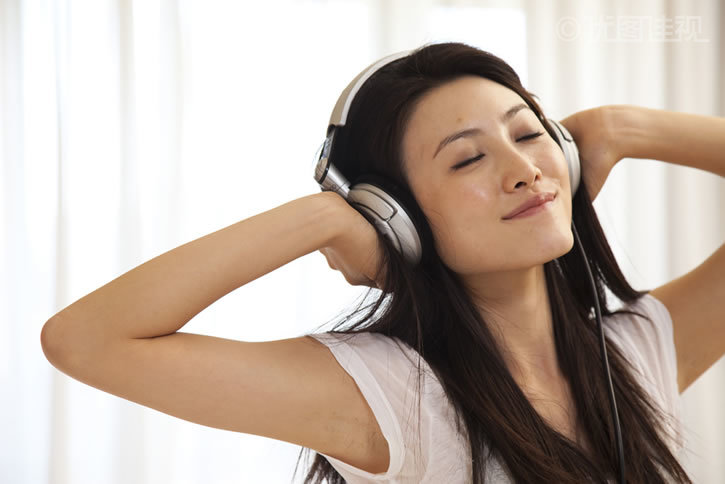 图片标题:年轻女人戴耳机听音乐