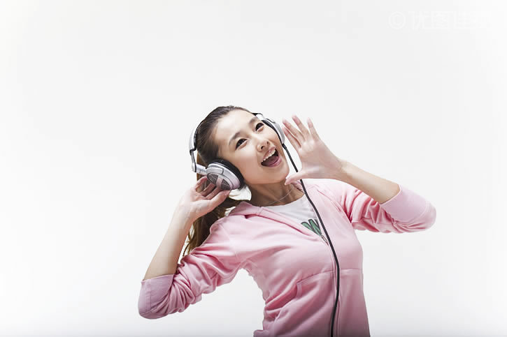 快乐的年轻女人戴耳机听音乐