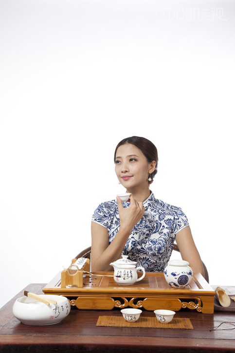 棚拍身穿旗袍的年轻女人喝茶