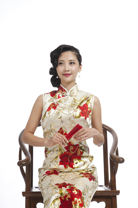 棚拍身穿旗袍的年轻女人拿红色折扇