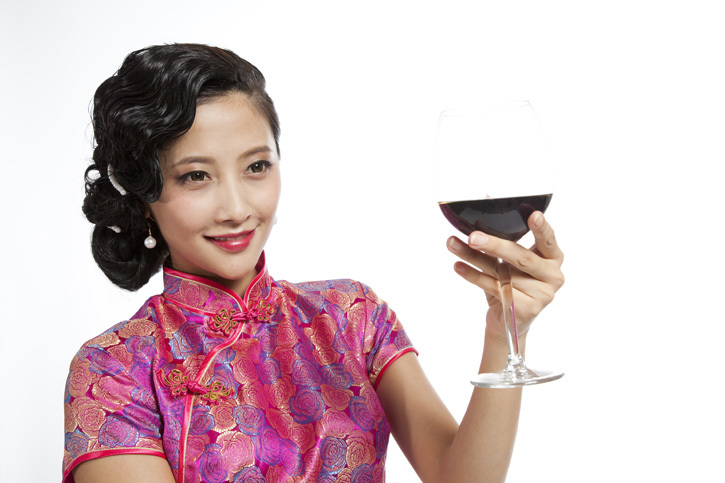 棚拍身穿旗袍的年轻女人举杯