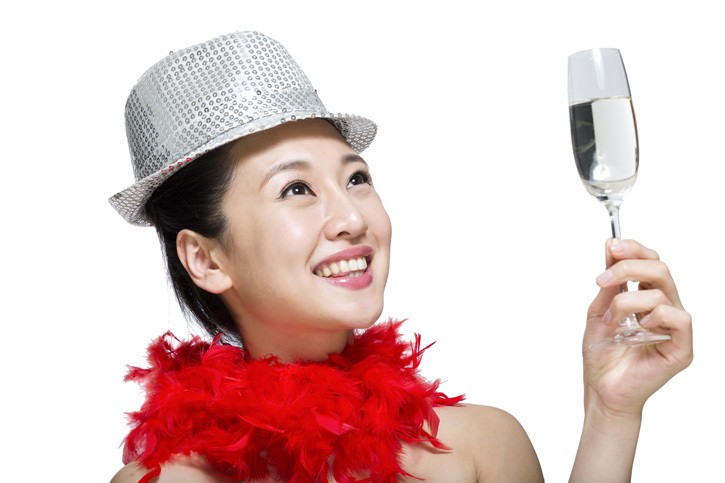 棚拍戴礼帽的年轻女人举着香槟酒杯