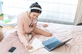 年轻女子在床上使用电脑